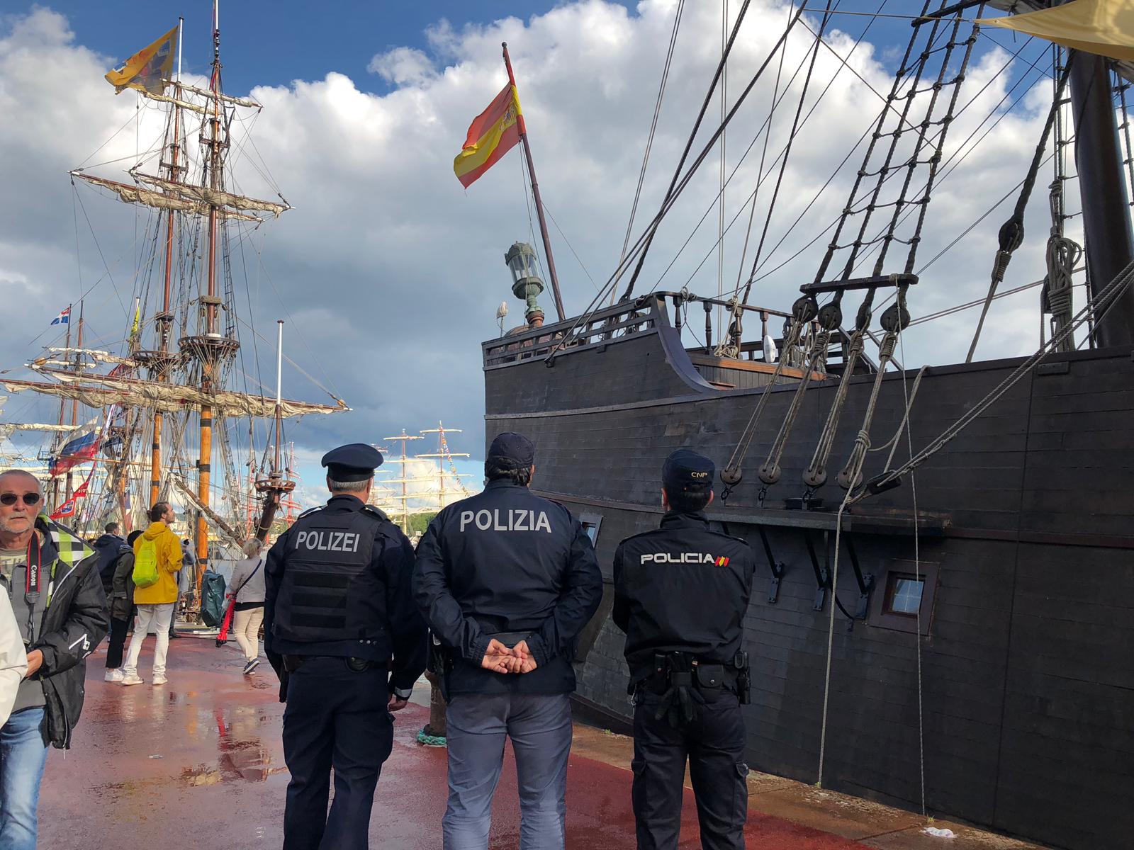Policía Nacional con agentes de otros países uniformados frente a barca con bandera española.